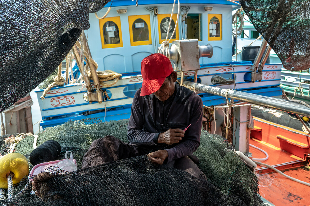 Fishing industry in Samut Sakhon, Thailand. Thailand is a top 5 global seafood producer, with exports reaping over $7 billion. But the profitable industry supplying consumers around the world with cheap seafood comes at a high cost to both the environment and to workers. The overwhelming majority of workers in Thailands fishing and seafood processing industries are migrants from Myanmar, Laos and Cambodia. Labour brokers recruit from vulnerable communities, promising favourable employment in the construction, manufacturing, or agriculture industries. Migrants often incur debt from their recruitment, fees and costs associated with transportation and securing employment in Thailand. These debts are paid off through deductions from workers earnings with employers and brokers frequently using debt manipulation to inflate the amounts and force people into bonded labour. This and the other images in this collection are showing the context in which the Freedom Fund Thailand hotspot operates. They show the location as well as the boats on which migrant workers work. They also show facilities for processing seafood and the markets in which seafood is traded. We do not have names or stories of any of the individuals shown in this collection because that was not the purpose of this commission. Jittrapon Kaicome / The Freedom Fund